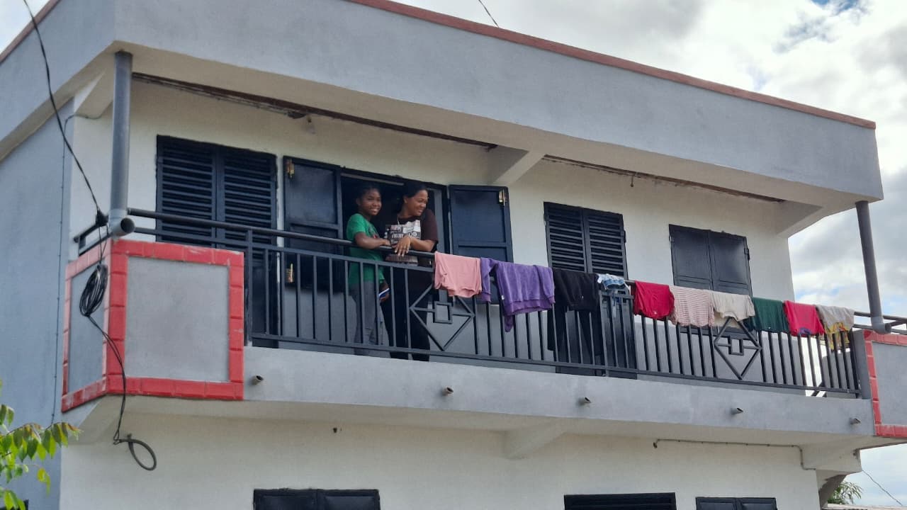 La maison presque terminée, avec ses habitants sur le balcon